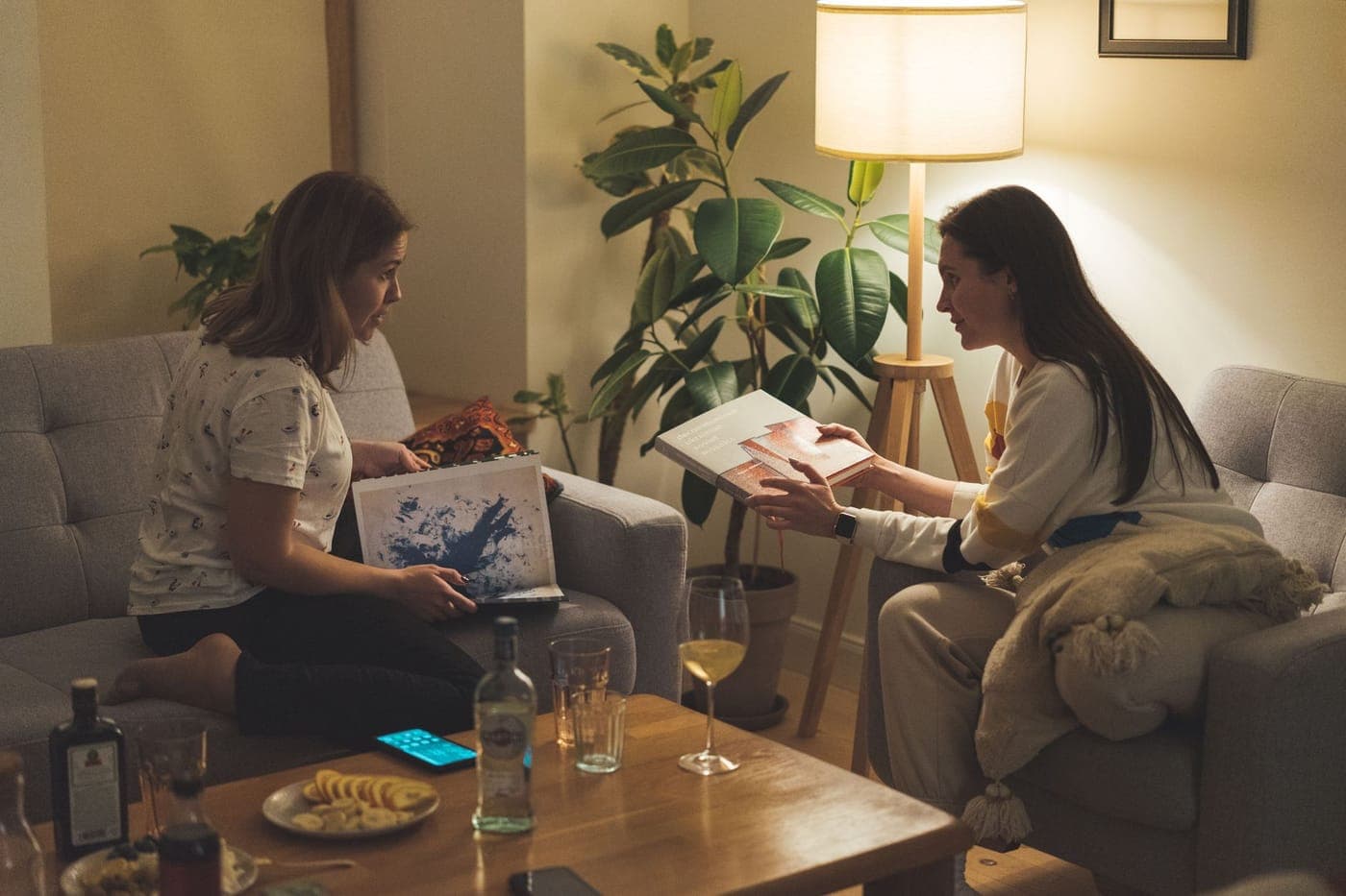 Friends talking around a table with books and coffee