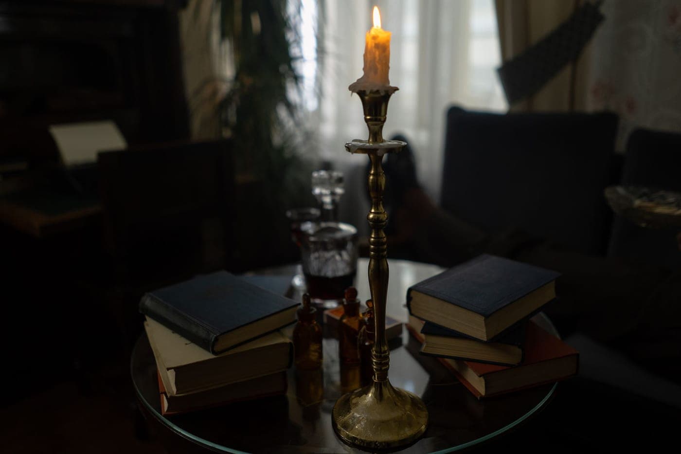 A candle burning beside a book at night