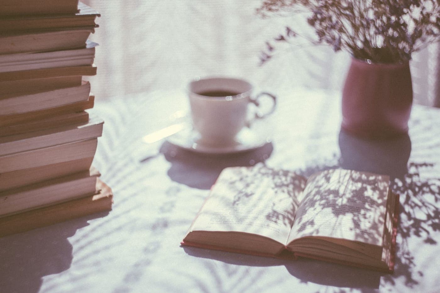 A book open beside a cup of coffee