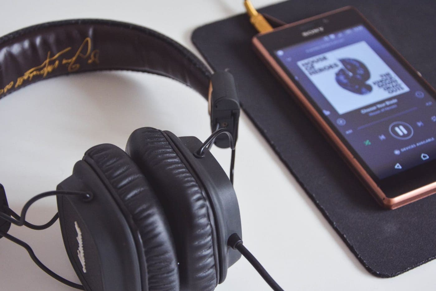 Headphones resting beside a phone on a desk