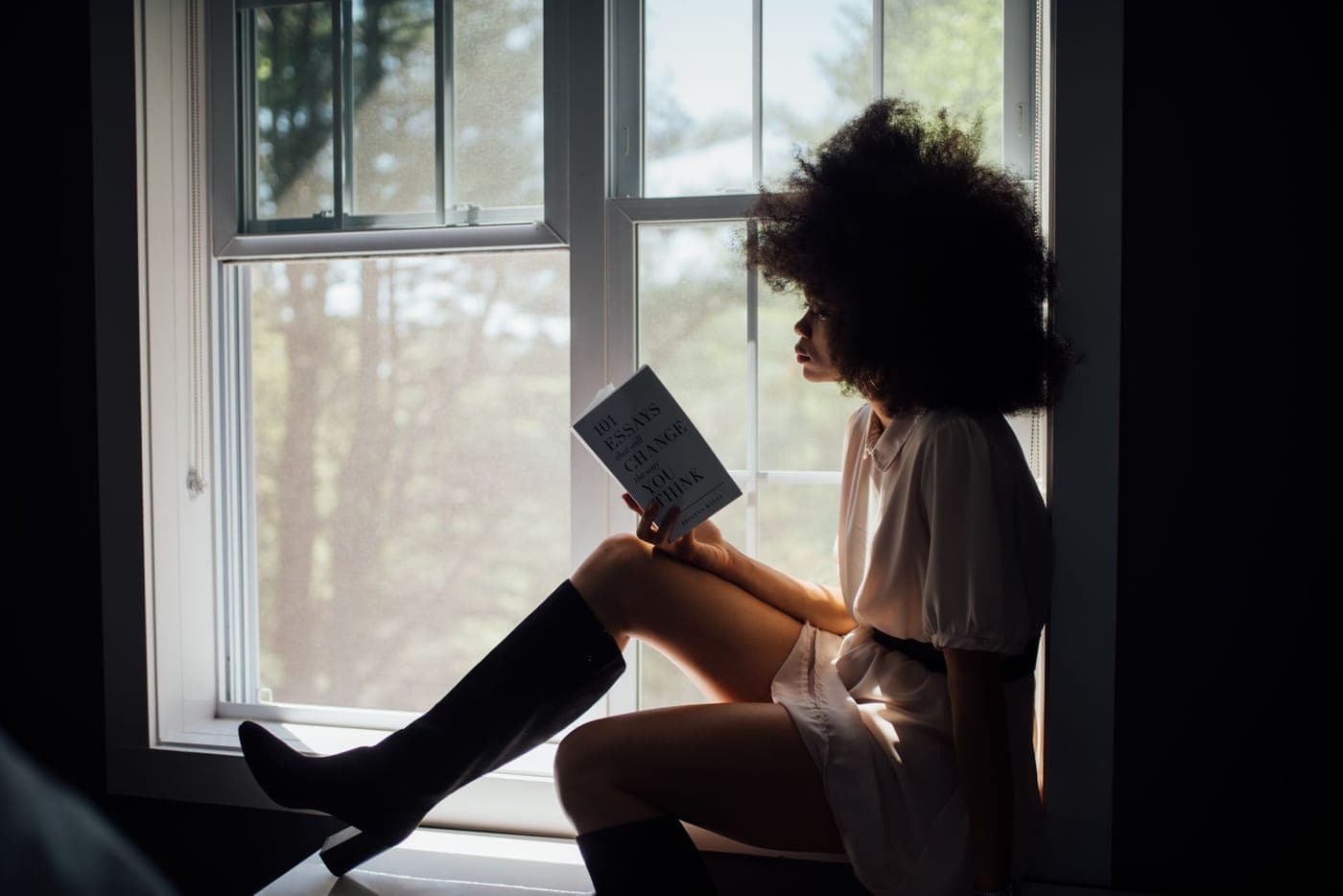 Someone reading by a window in soft daylight