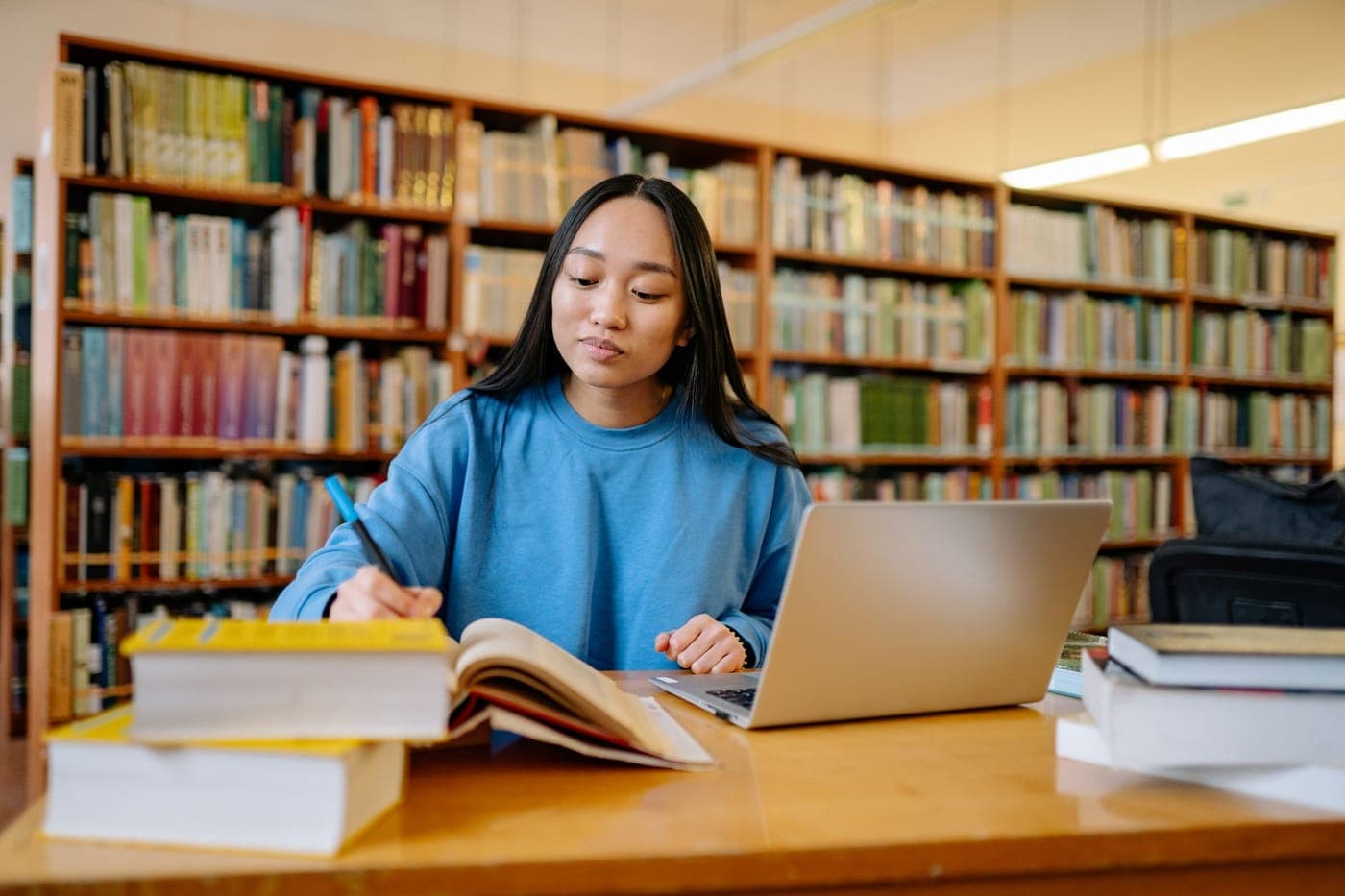 A student desk with a laptop, notebook and books