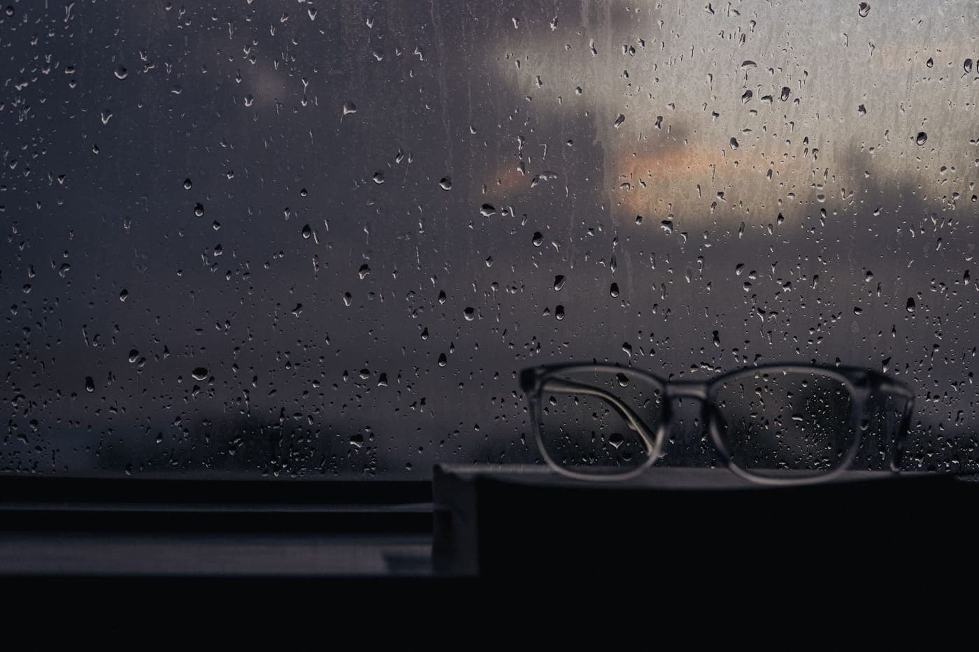 Rain running down a dark window pane